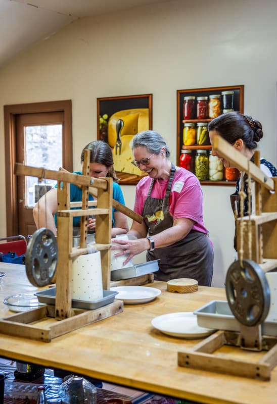 Pressing cheese in a wooden cheese press
