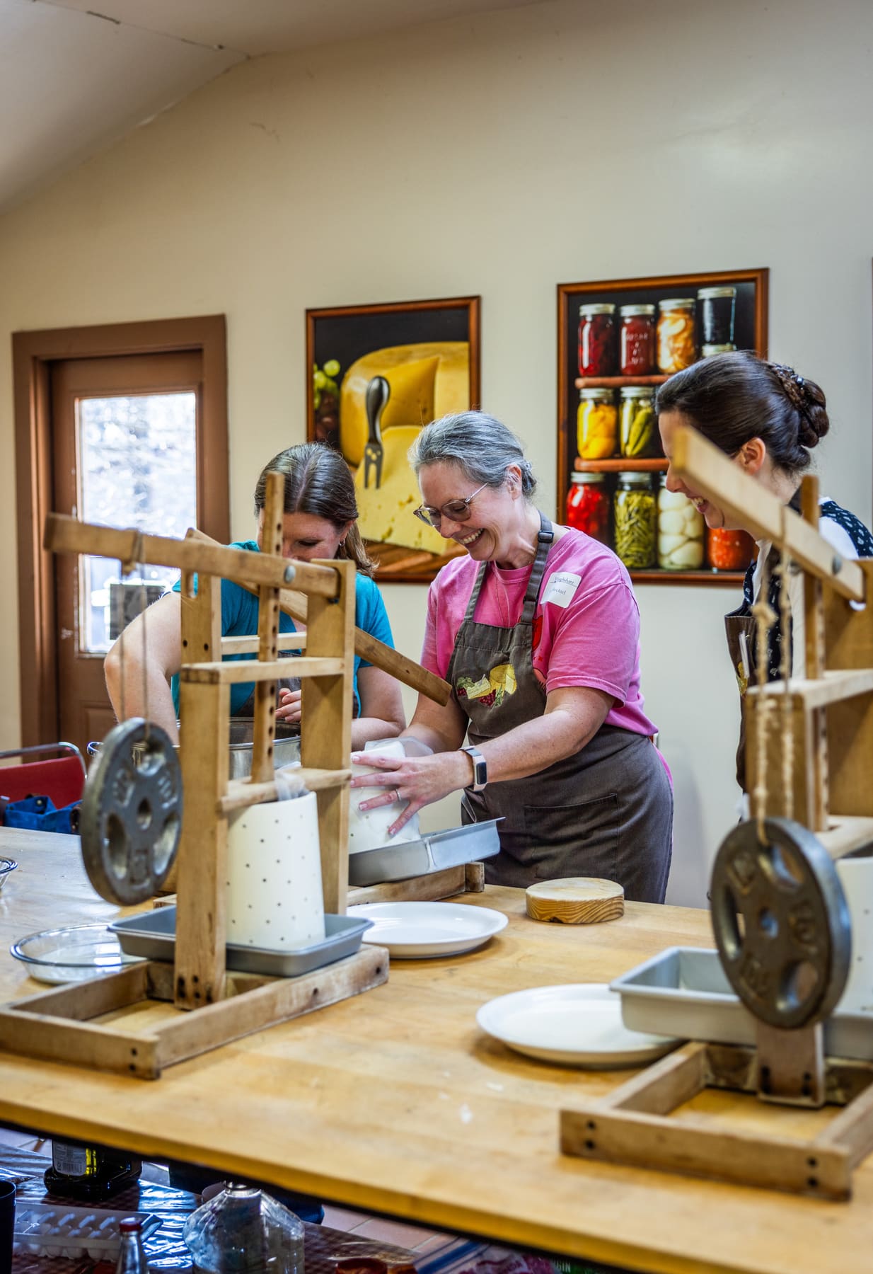 Pressing cheese by hand in a wooden cheese press