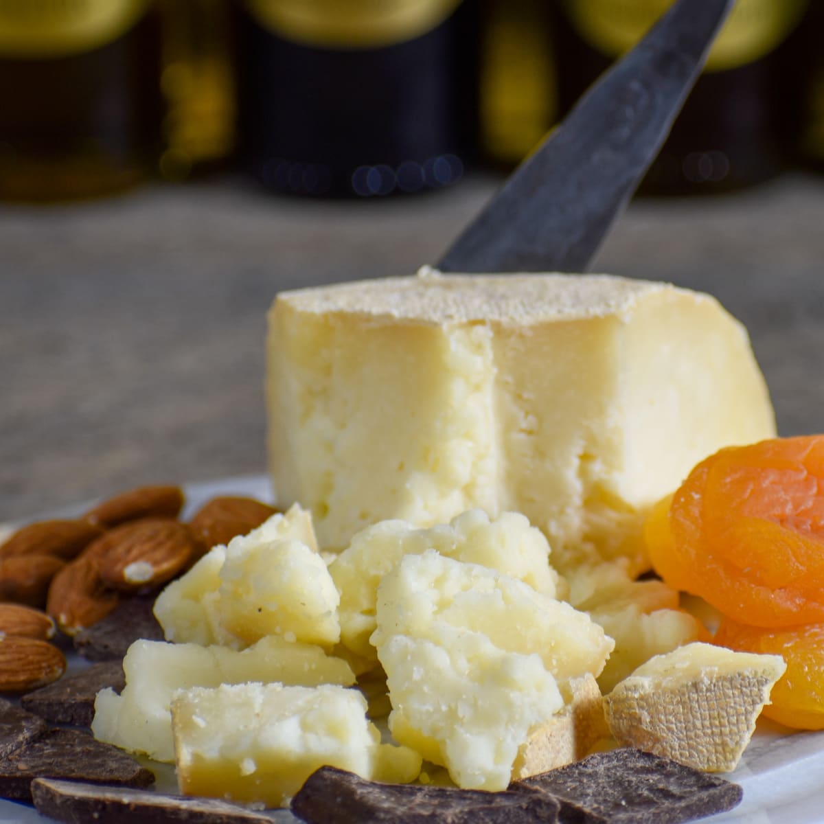 A wedge of Havarti with almonds and dried apricots