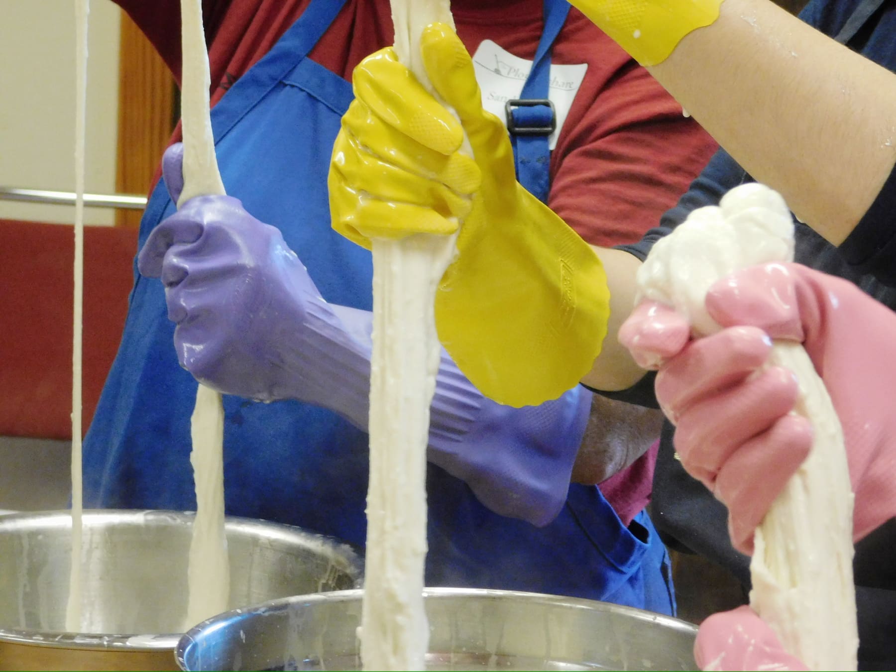 Stretching curd by hand over the vat
